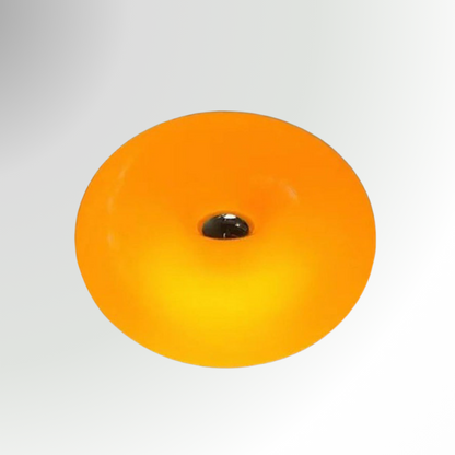 Bauhaus, a circular, donut-shaped, glass lamp. Featured in orange, pictured against a grey background.