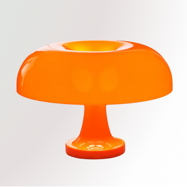 Giancarlo, a modern orange table lamp with a silhouette resembling a mushroom, pictured against a white pedestal.