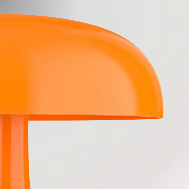 Zoomed and detailed shot of Giancarlo, a modern orange table lamp with a silhouette resembling a mushroom, pictured against a light grey background.
