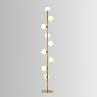 Atlas, a modern floor lamp, in brushed gold, with 9 circular bulbs on a grey background.
