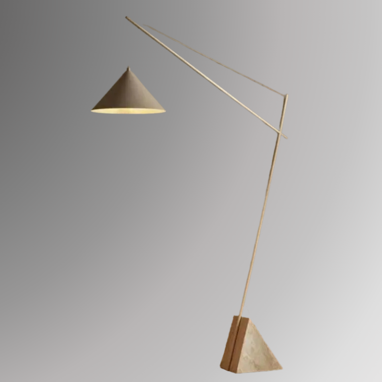 Quentin, a sculptural and minimalist floor light with a beige hued, geometric iron body, and a triangular marble base. Pictured against a greyscale background.