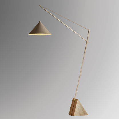 Quentin, a sculptural and minimalist floor light with a beige hued, geometric iron body, and a triangular marble base. Pictured against a greyscale background.