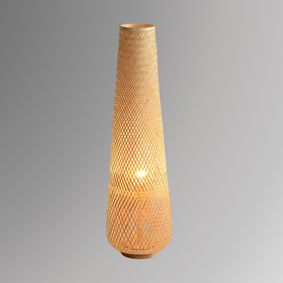 Solace, a cylindrical wicker floor lamp, in a natural light wheat color, illuminated and pictured against a grey scale background.
