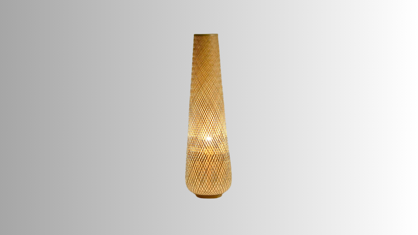 Solace, a cylindrical wicker floor lamp, in a natural light wheat color. Solace is illuminated against a greyscale background.